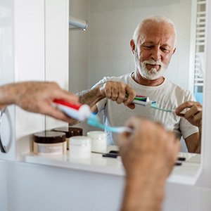 A man brushing his teeth in a mirror