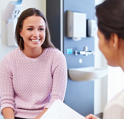 Woman in dental chair smiling at dentist