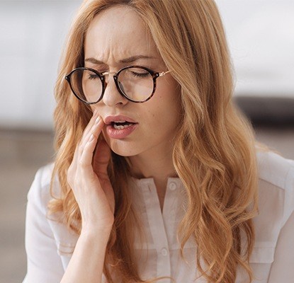 Woman in pain holding jaw