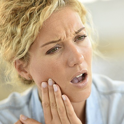 Woman holding cheek in pain