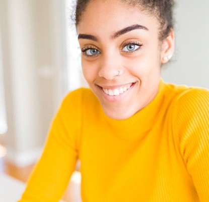 person sitting in their house and smiling