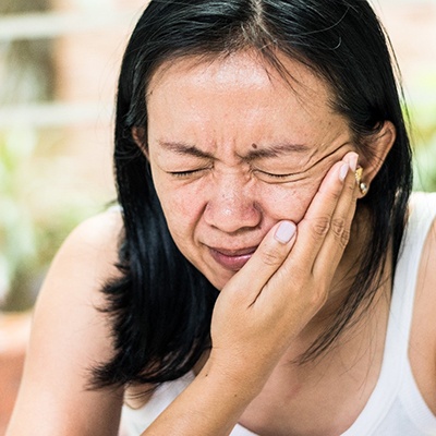 Woman in pain needing an emergency dentist.