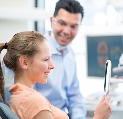 Woman looking at her smile in mirror