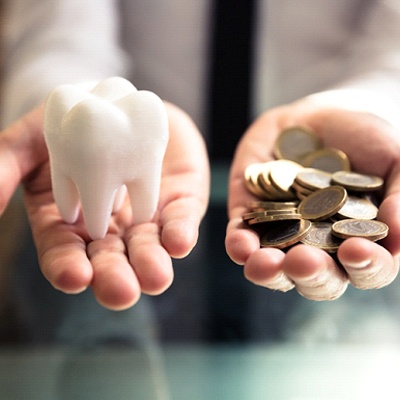 person holding tooth in one hand, and money in the other
