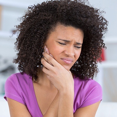 Woman holding jaw in pain