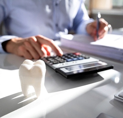 Using calculator to contemplate cost of dental implants