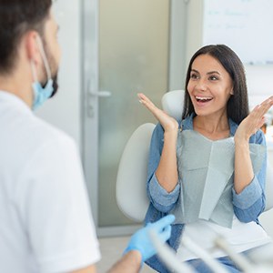 Excited woman smiling while talking to East York dentist