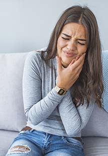 woman holding jaw in pain