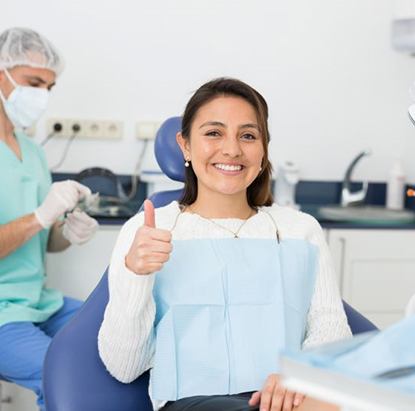 Happy dental patient making thumbs up gesture