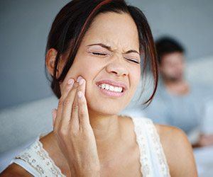 Woman in pain holding jaw