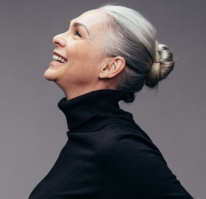 portrait of a person smiling against a gray background