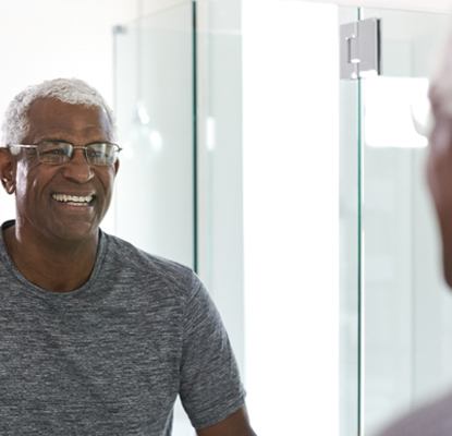 person smiling in a bathroom mirror