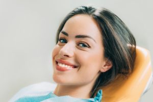 Woman with dark hair smiling in dental chair