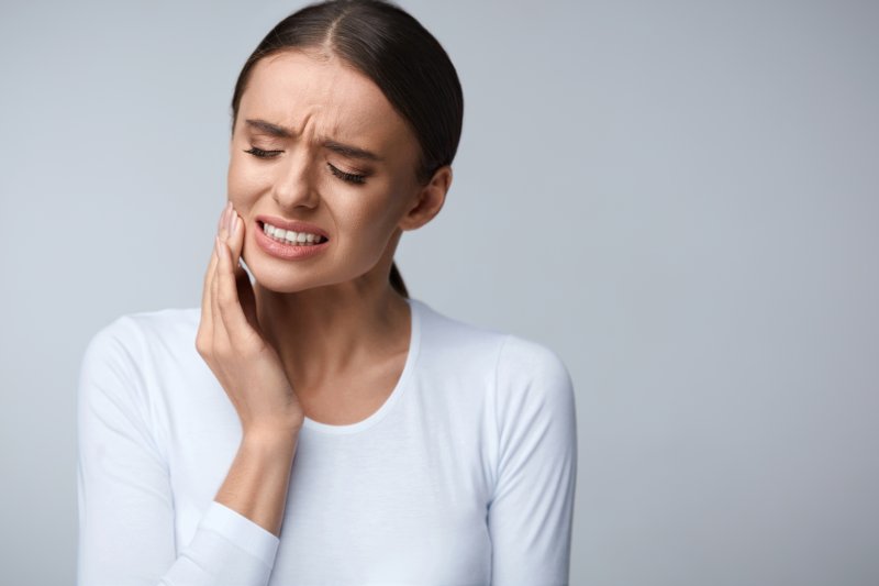Woman with toothache needing to see emergency dentist